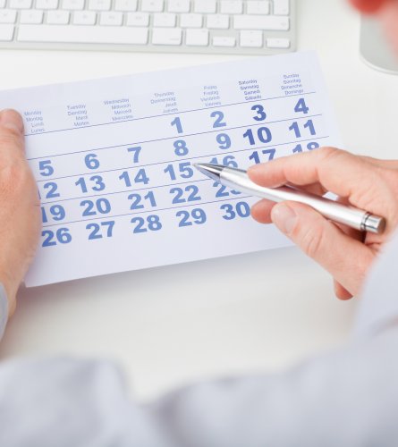 Hand Holding Calendar And Pen